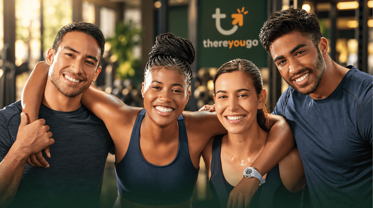 Four friends smiling together at the gym